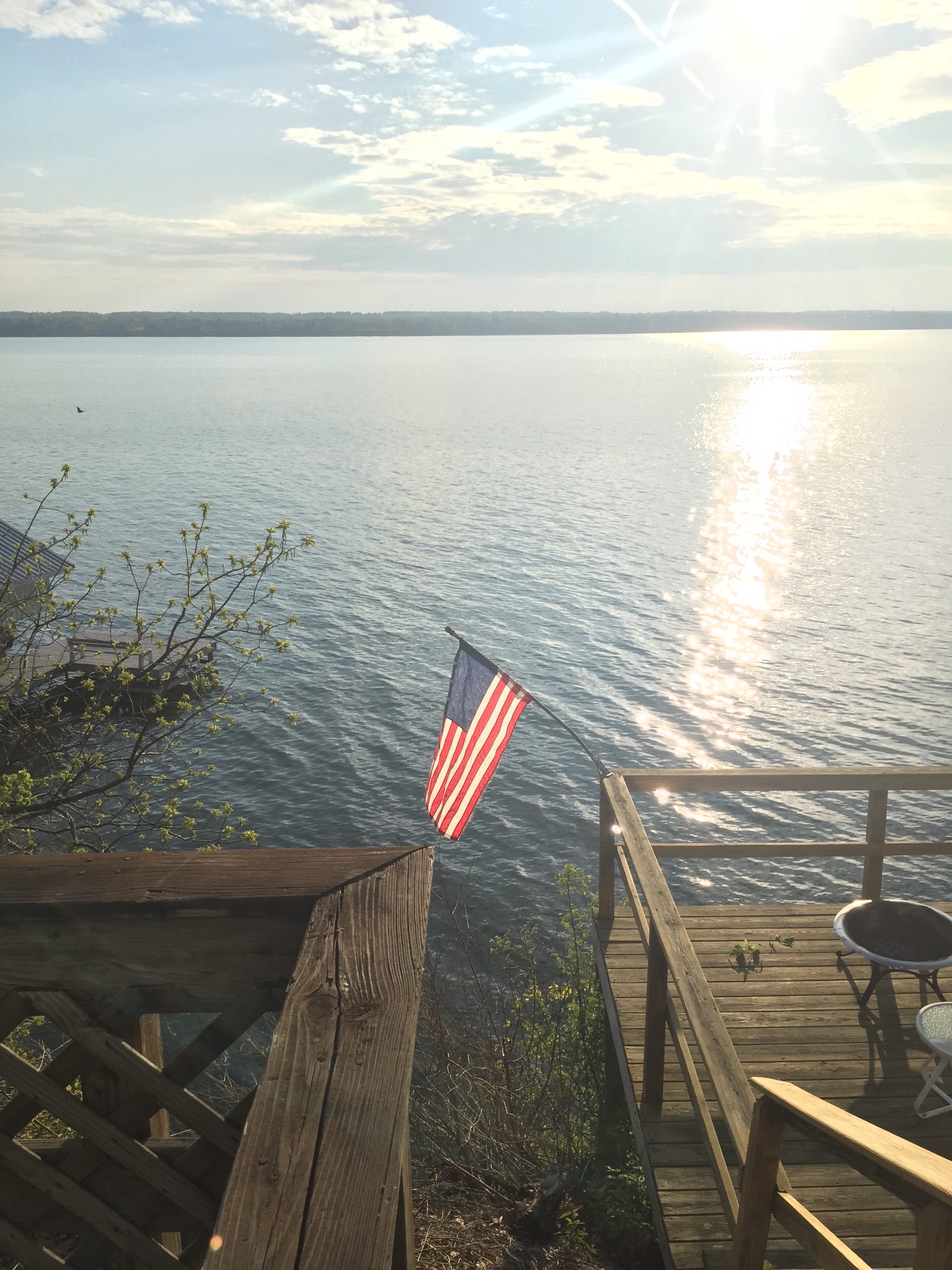 Lakeside dock with an American flag overlooking calm water